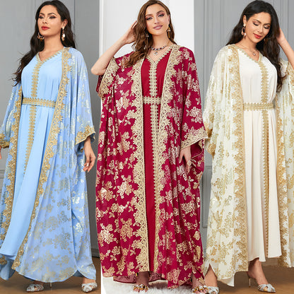 Three women wearing embroidered kaftans in blue, red, and white.